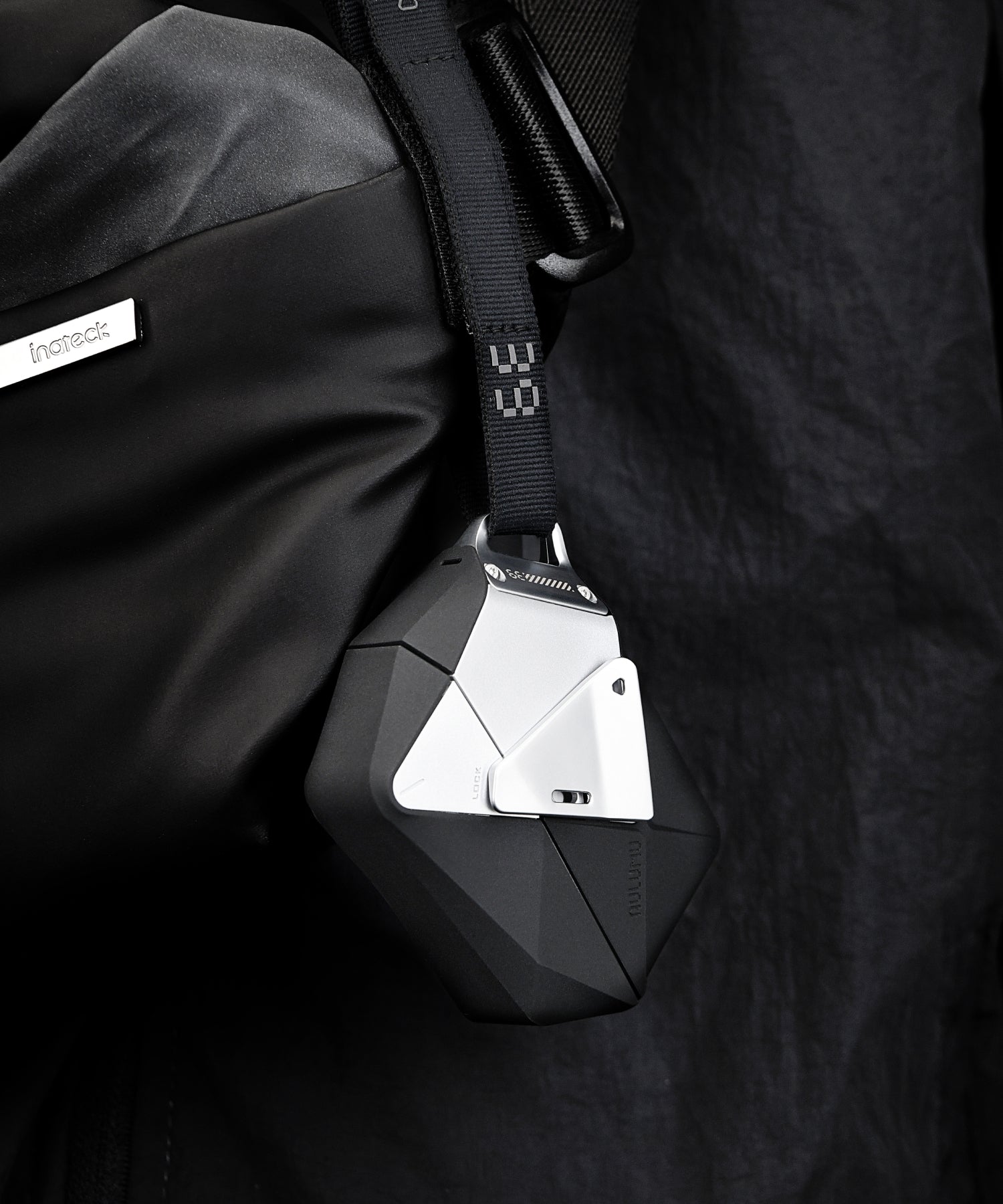AULUMU A39 geometric AirPods Pro 3 case clipped to a backpack strap using the included lanyard and lock.
