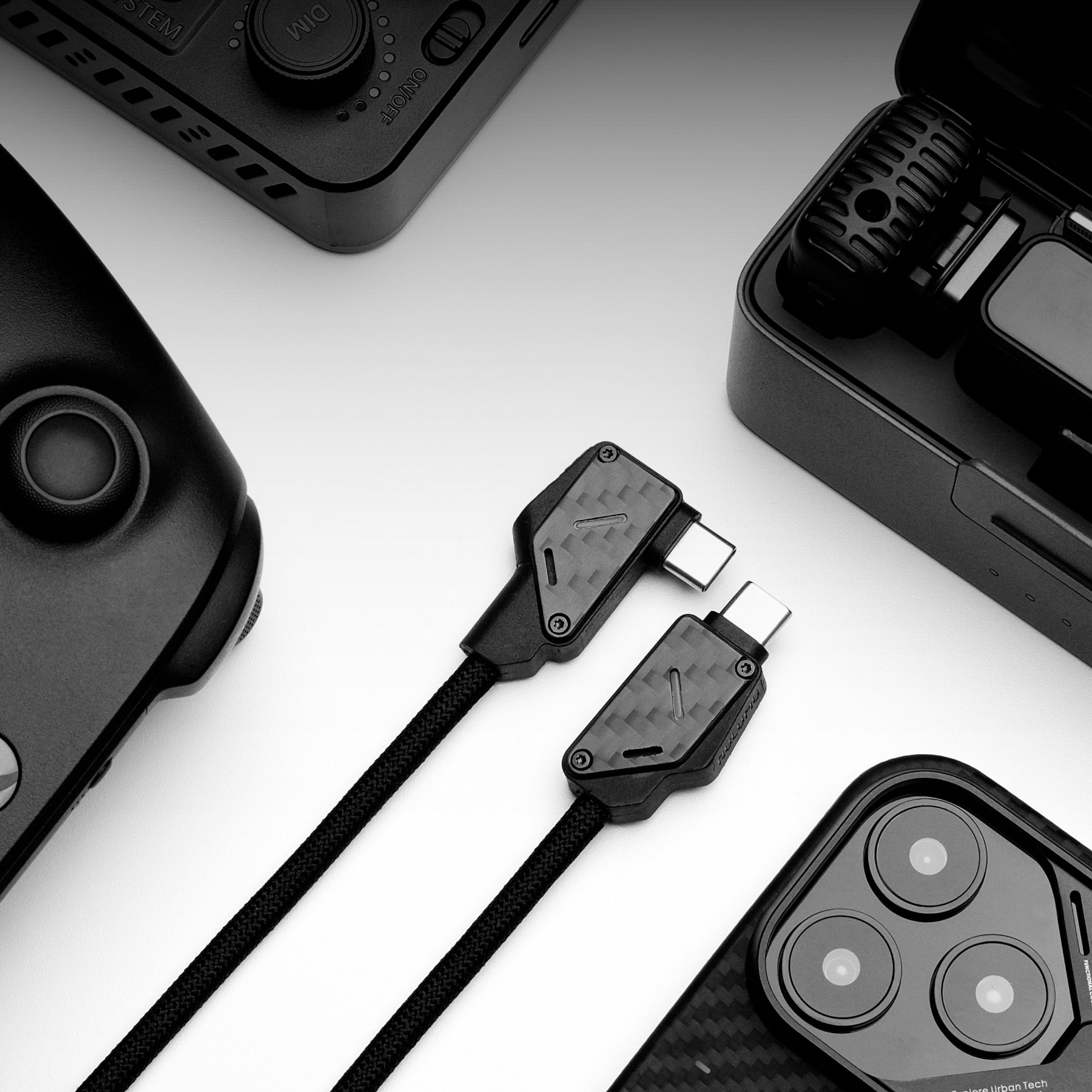 Flat lay of M07 USB-C cables with gaming controller and tech gear on white background